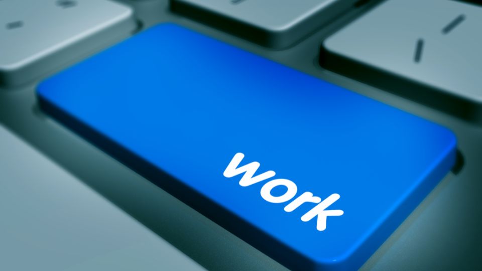 Egy számítógép billentyűzetének kék gombja, rajta a 'work' felirattal.